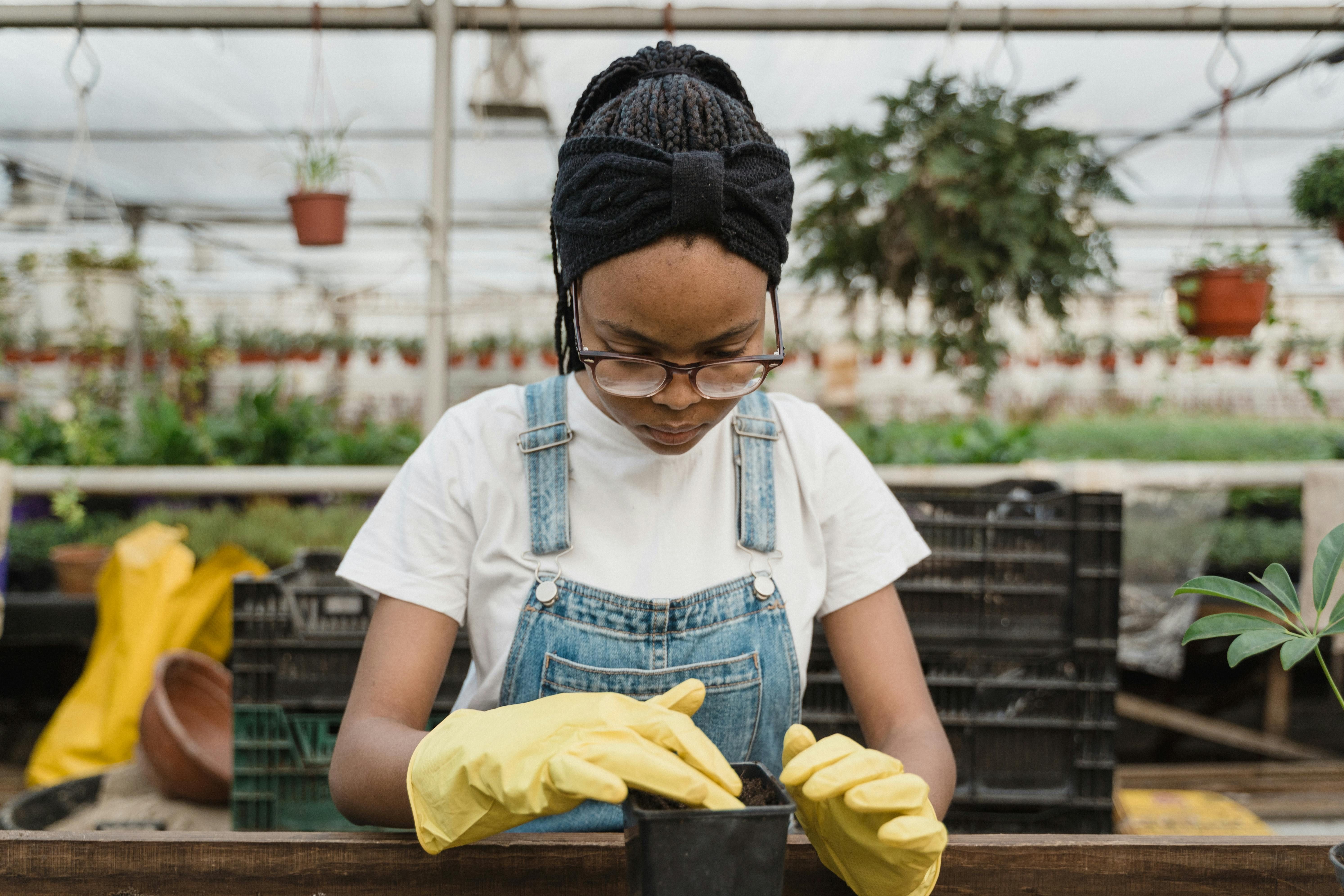 Woman with Yellow Gloves Preparing Soil for Planting